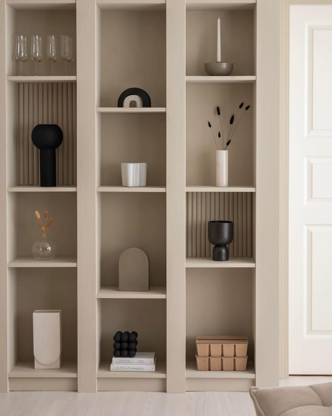 a white shelving unit with white shelves and white vases