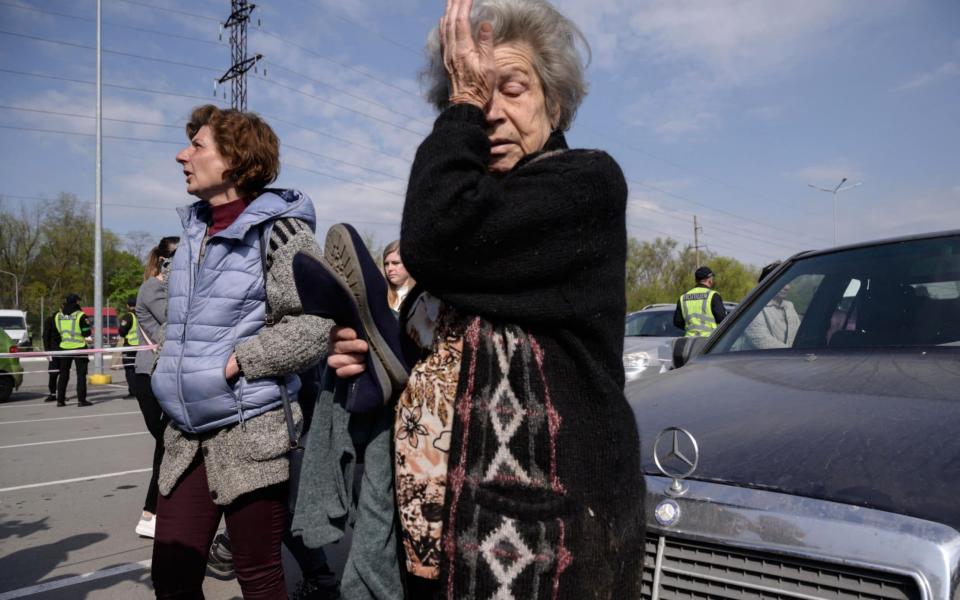 Mother and daughter Dina (R) and Natasha (L) from Mariupol react as they arrive in their own vehicle, separate from a larger convoy expected later, at a registration and processing area for internally displaced people arriving from Russian-occupied territories in Ukraine, in Zaporizhzhia on May 2, 2022. - Ed Jones/AFP