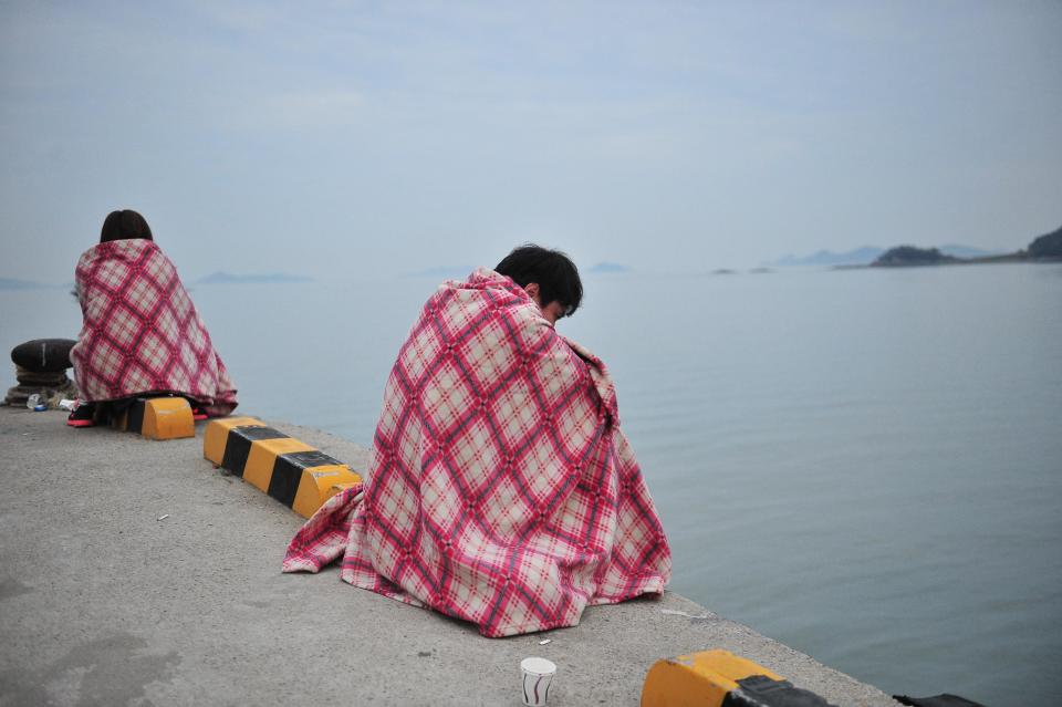 Familiares de los pasajeros del ferry que naufragó cerca de la costa de Corea del Sur, esperan noticias sobre los desaparecidos el 16 de abril de 2014