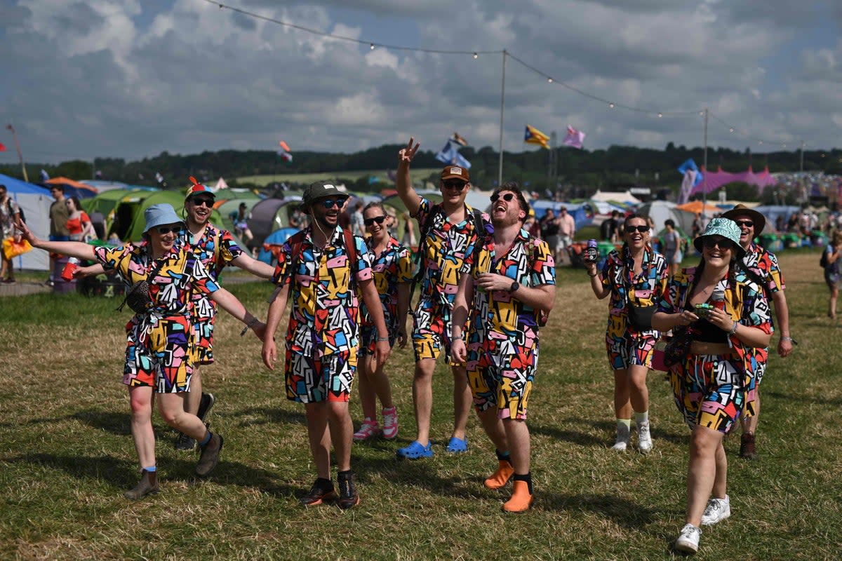 Festivalgoers enjoy the summer sunshine on day two of the Glastonbury festival in the village of Pilton in Somerset (AFP via Getty Images)