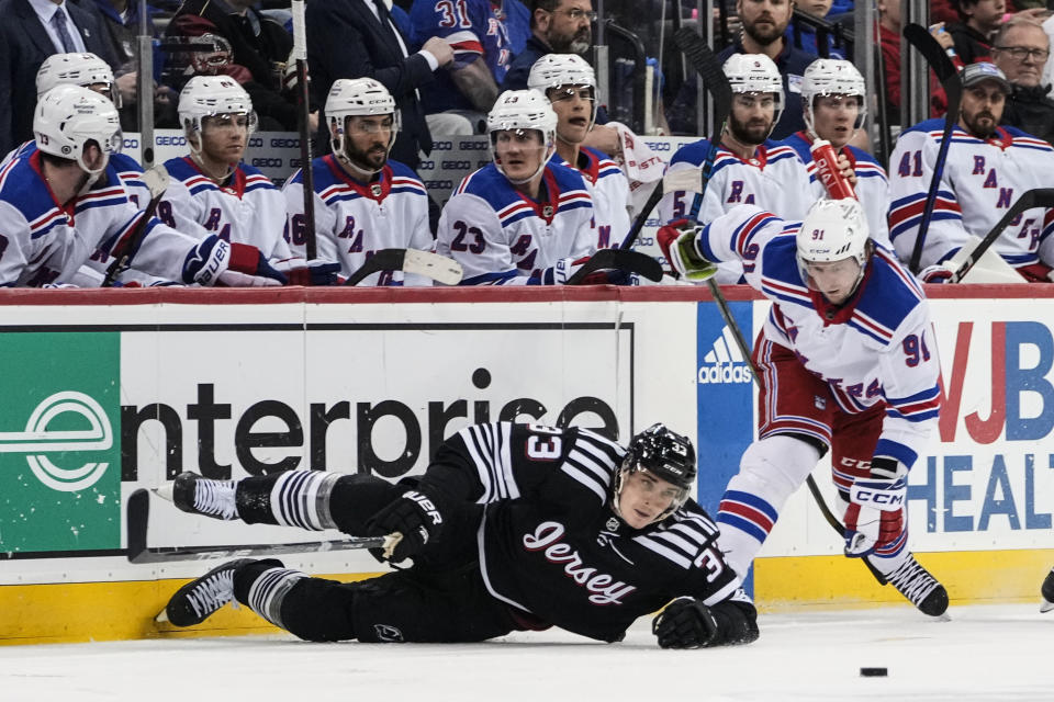 New York Rangers' Vladimir Tarasenko (91) fights for control of the puck with New Jersey Devils' Ryan Graves (33) during the third period of an NHL hockey game Thursday, March 30, 2023, in Newark, N.J. The Devils won 2-1. (AP Photo/Frank Franklin II)
