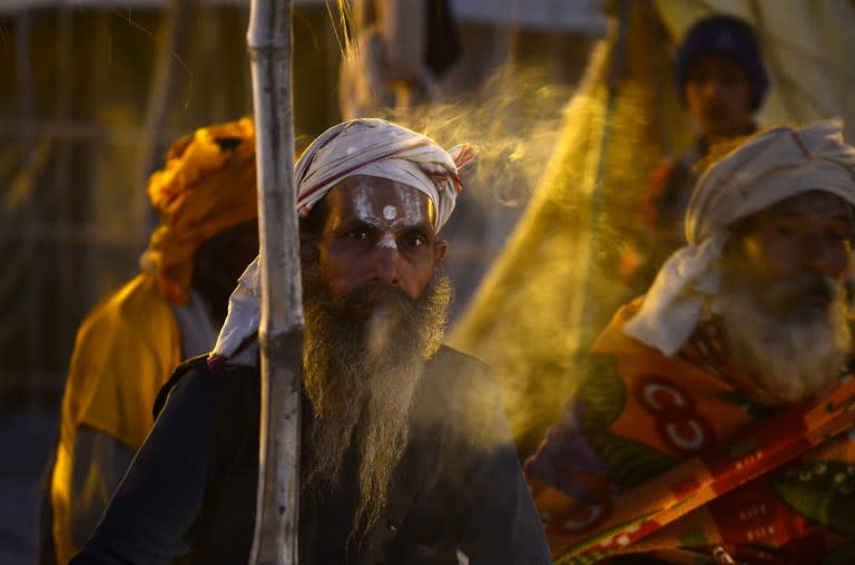 <p>An Indian Sadhu smokes alocal cigarette or ‘Bidi’ after performing evening prayers at Sangam, the confluence of the Rivers Ganges, Yamuna and mythical Saraswati during the annual Magh Mela festival in Allahabad on February 4, 2016. </p>