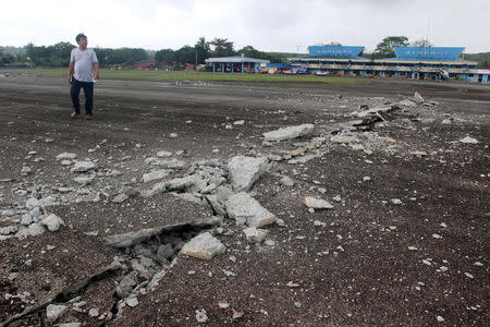 A man walks on the damaged runway at Surigao airport after an earthquake hit Surigao city, southern Philippines February 11, 2017. REUTERS/Roel Catoto