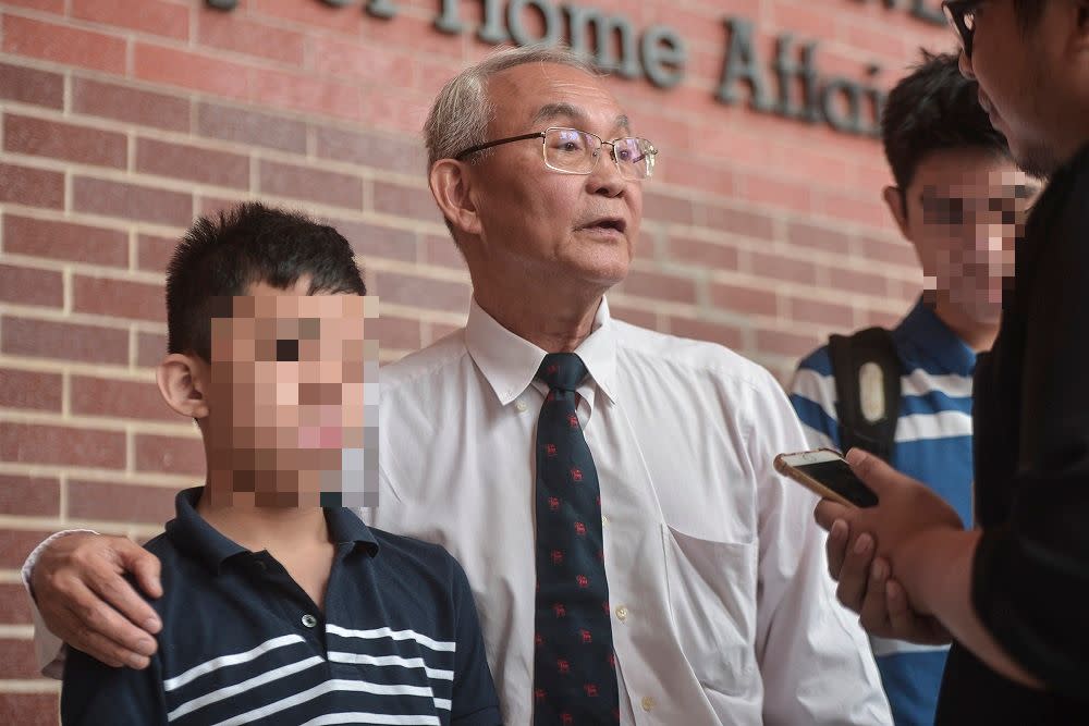 Tan Khek Pheng (center) and his son Yu Sheng Meng (left) speak to reporters at the Ministry of Home Affairs in Putrajaya September 27, 2019. — Picture by Shafwan Zaidon