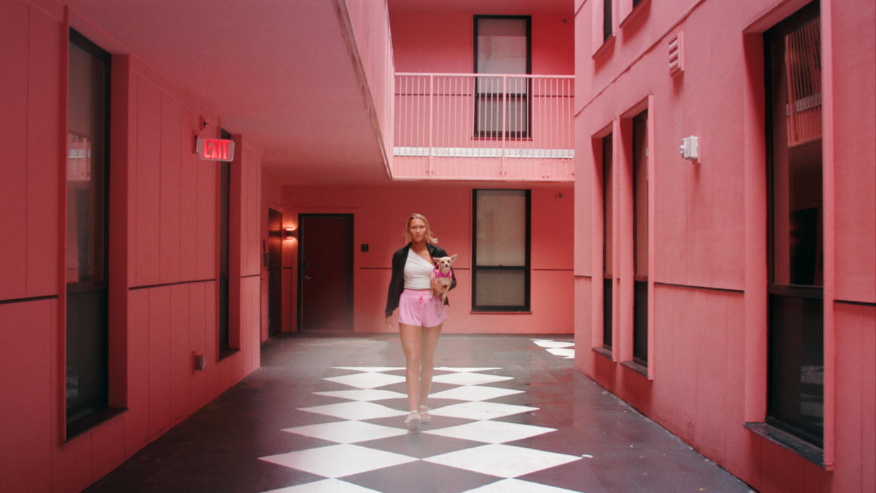 University of Alabama student walking through a pink courtyard