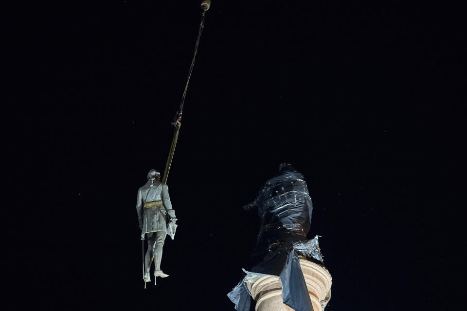 Workers remove part of the monument to Catherine II, also known as "Monument to the Founders of Odesa" in Odesa, Ukraine, early Thursday, Dec. 29, 2022. The decision to dismantle the monument consisting of sculptures of Russian Empress Catherine II and her associates was made recently by Odesa residents by electronic voting. (AP Photo/LIBKOS)