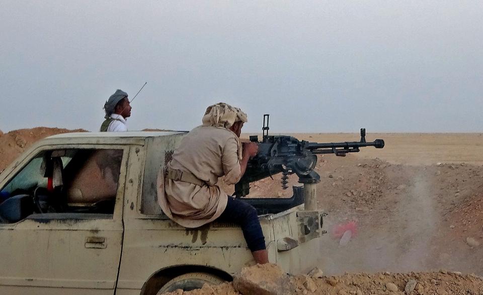 A combatant mans a heavy machine gun as forces loyal to Yemen's Saudi-backed government clash with Houthi rebel fighters in central Yemen, on Nov. 22, 2020.