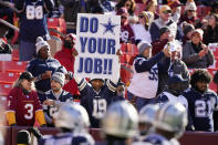 A fan holds up a sign during pregame warmups prior to the start of the first half of an NFL football game between the Dallas Cowboys and Washington Football Team, Sunday, Dec. 12, 2021, in Landover, Md. (AP Photo/Alex Brandon)