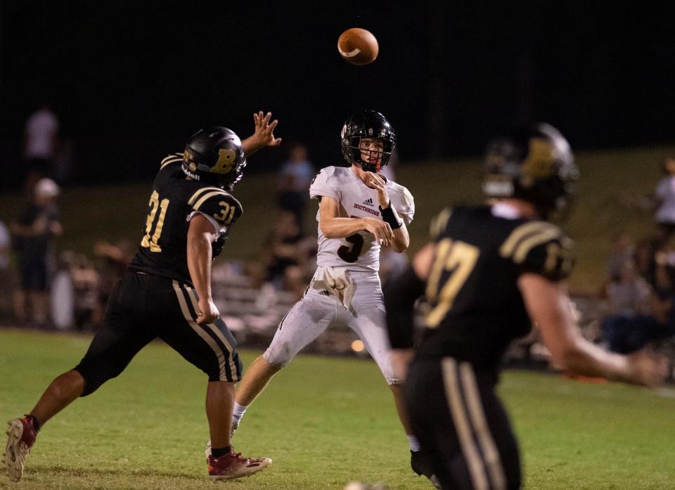 Southridge's Hudson Allen (5) throws downfield while pressured by Boonville’s Elijah Biggins (31) during their game at Bennett Field in Boonville, Ind., Friday night, Aug. 26, 2022. Southridge beat Boonville in a hot and humid dogfight 13-0.