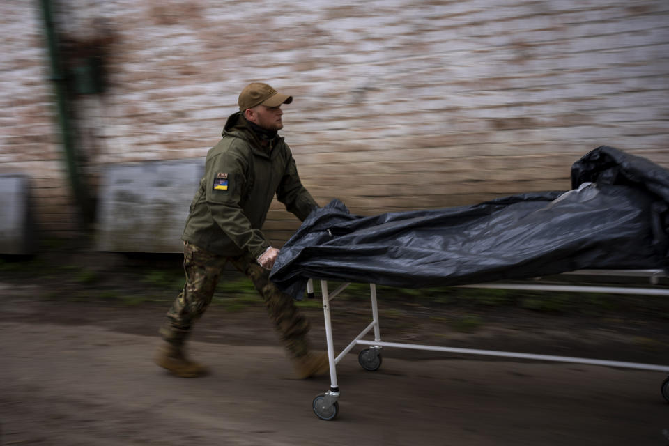 Darrell Loveless works moving dead bodies from refrigerated trucks to the morgue in Bucha, on the outskirts of Kyiv, Monday, April 25, 2022. (AP Photo/Emilio Morenatti)