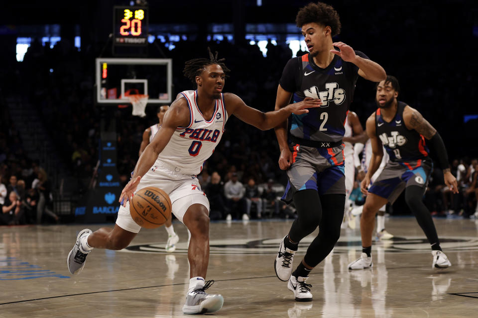 Philadelphia 76ers guard Tyrese Maxey (0) drives to the basket past Brooklyn Nets forward Cameron Johnson during the first half of an NBA basketball game, Sunday, Nov. 19, 2023, in New York. (AP Photo/Adam Hunger)