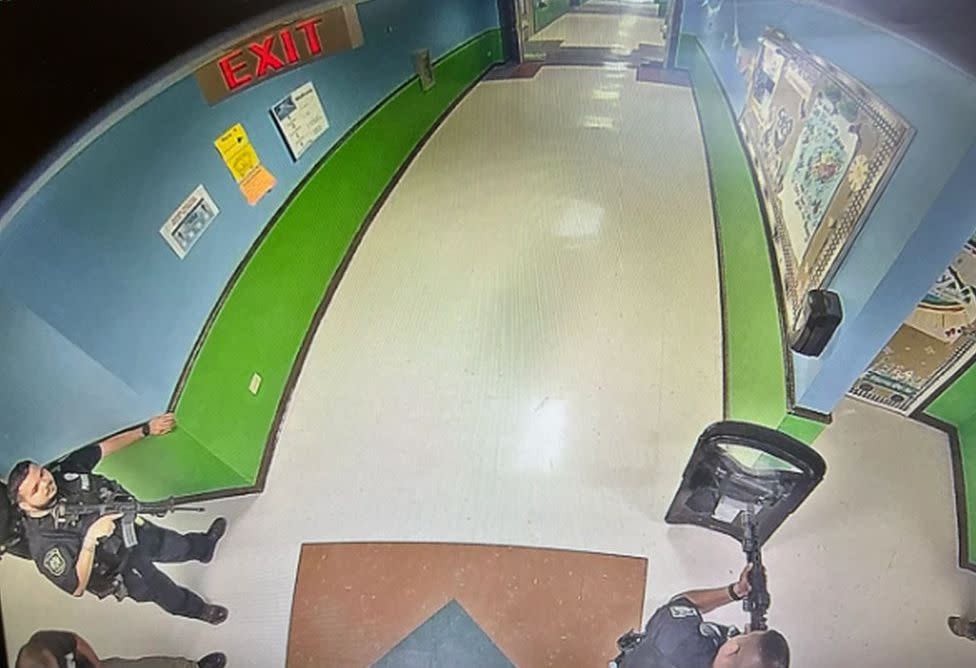 The first images showing armed police waiting in a corridor during last month's school shooting in Uvalde, Texas have emerged.