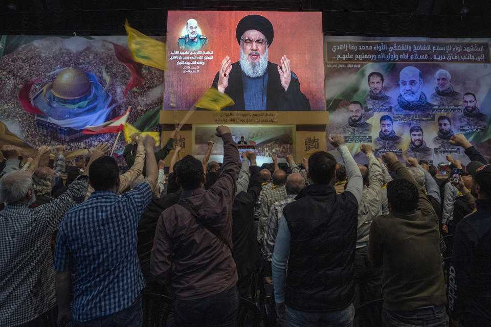 Hezbollah leader Sayyed Hassan Nasrallah speaks in a televised address via a video link during a ceremony to commemorate the death of the Iranian Revolutionary Guard Gen. Mohammad Reza Zahedi and six officers, who were killed by an Israeli airstrike that demolished Iran's consulate in Syria last Monday, in the southern suburbs of Beirut, Lebanon, Monday, April 8, 2024. Nasrallah paid tribute to Zahedi, who spent 12 years of his career as a top general at the Iranian Revolutionary Guards elite Quds Force with Hezbollah. The Hezbollah leader said he played a key role in strengthening and empowering the group which fought several wars with Israel, and has become Iran's key proxy in the region. (AP Photo/Hassan Ammar)