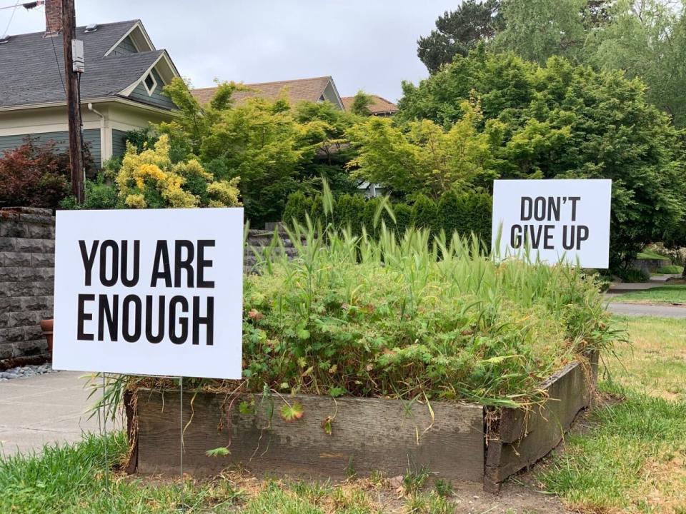 Signs reading 'You Are Enough' and 'Don't Give Up' as part of Seattle man Colby Wallace's 'You Matter' campaign