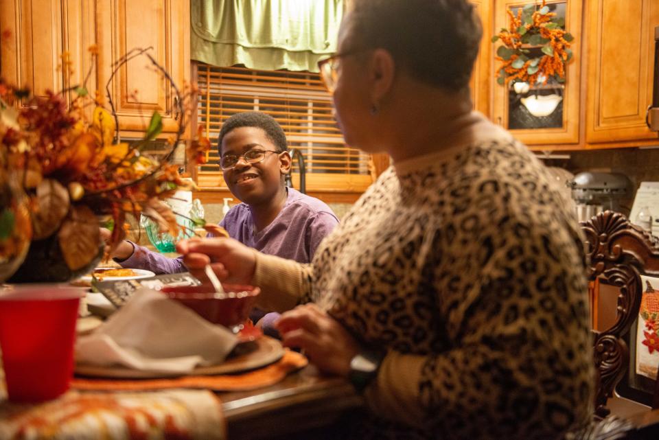 Ty Boyd is amused after watching "The Price is Right" with his mother, Kim, as they eat dinner inside their home in Martin, Tenn., on Monday, Oct. 16, 2023. Boyd worries that if Tennessee refuses federal funding for education that education for those with disabilities in public schools could suffer as a result.