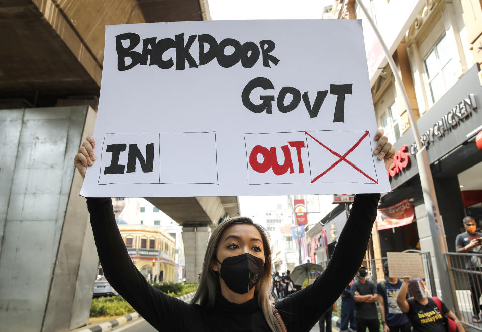 A protester holds a placard during a demonstration demanding the prime minister step down near the Independence Square in Kuala Lumpur, Saturday, July 31, 2021. Hundreds of black-clad Malaysian youths have rallied in the city center, demanding Prime Minister Muhyiddin Yassin resign for mismanaging the coronavirus pandemic that has worsened. (AP Photo/FL Wong)