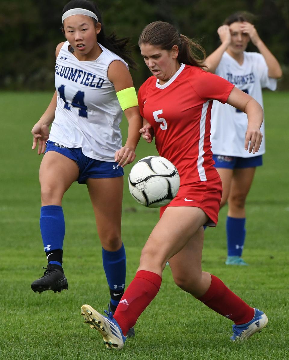 Kathryn Penird of Red Jacket tries to block a pass from Bloomfield's Madeline Johnston.