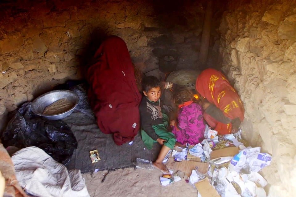 Benazir, right, lights a fire with discarded paper to cook bread with a group of children in Herat. (NBC News)