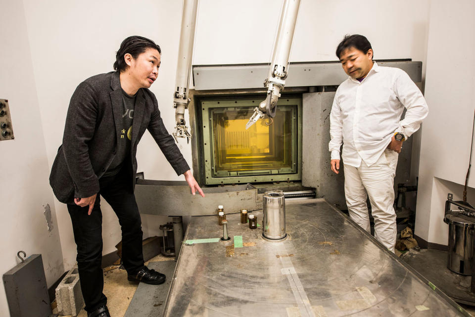 Masashi Aono, left, in the radiation room at the Tokyo Institute of Technology where his team produced formamine by exposing chemicals to radiation. <cite>Nerissa Escanlar</cite>