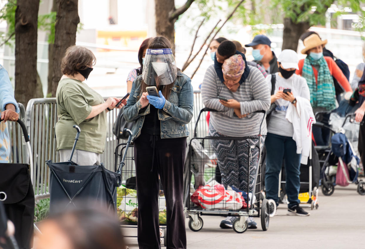 NEW YORK, NEW YORK - SEPTEMBER 24: People stand in line to receive food donations at a Food Bank for New York City pop up food pantry outside Lincoln Center for the Performing Arts as the city continues Phase 4 of re-opening following restrictions imposed to slow the spread of coronavirus on September 24, 2020 in New York City. The fourth phase allows outdoor arts and entertainment, sporting events without fans and media production. (Photo by Noam Galai/Getty Images)