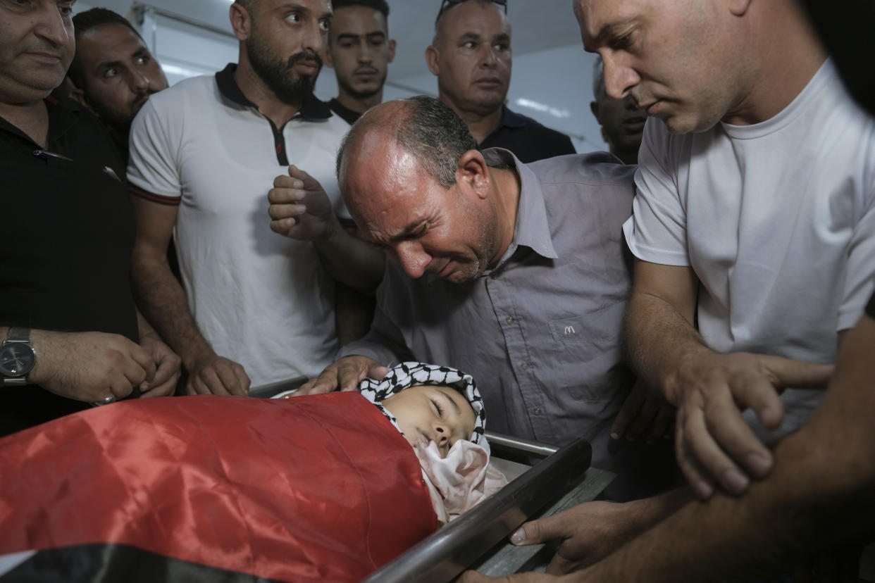 Father of 7-year-old Palestinian boy Rayan Suleiman, mourns over his son's body at a hospital in the West Bank village of Beit Jala just before his funeral Friday, Sept. 30, 2022. The U.S. State Department has called on Israel to open a "thorough" investigation into the mysterious death of the boy, who collapsed and died shortly after Israeli soldiers came to his home in the occupied West Bank. Relatives said he had no previous health problems and accused the army of scaring the child to death. The army called the death a tragedy and said its soldiers were not to blame. (AP Photo/Mahmoud Illean)