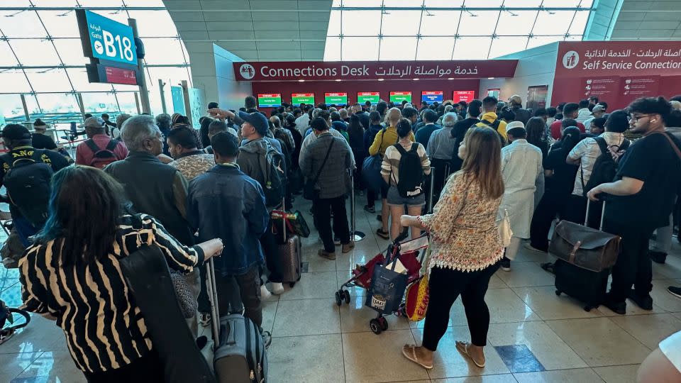 Passengers queue at a flight connection desk at the Dubai International Airport in Dubai on Wednesday. - AFP/Getty Images
