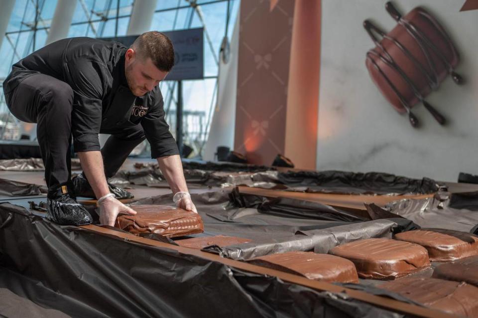 A Russell Stover chocolatier places giant chocolate specialty candies into a chocolate box during Russell Stover Chocolates attempt to break the Guinness World Record for the largest box of chocolate.