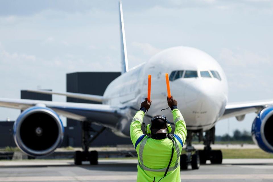 A United Airlines worker guides a plane at Dulles International Airport on June 17, 2022.