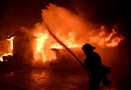 Firefighters battle a fast-moving wildfire that destroyed homes driven by strong wind and high temperatures forcing thousands of residents to evacuate in Goleta, California, U.S., early July 7, 2018. REUTERS/Gene Blevins