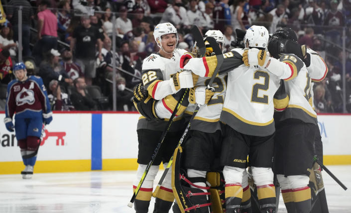 Vegas Golden Knights defenseman Nick Holden, goaltender Marc-Andre Fleury, defenseman Zach Whitecloud and right wing Reilly Smith celebrate with teammates after the Golden Knights scored in overtime of Game 5 of an NHL hockey Stanley Cup second-round playoff series, as Colorado Avalanche center Nathan MacKinnon, back, reacts Tuesday, June 8, 2021, in Denver. The Golden Knights won 3-2. (AP Photo/David Zalubowski)