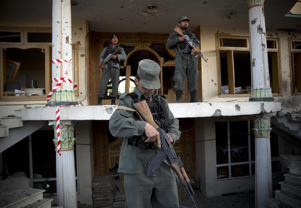 Afghan police guard an election office after the Taliban launched an assault with a suicide bomber detonating his vehicle outside an election office in Kabul, Afghanistan, Tuesday, March 25, 2014. Gunmen stormed into the building, trapping dozens of employees inside and killing many people. A candidate for a seat on a provincial council was among those killed, along with an election worker, a civilian and a policeman. (AP Photo/Anja Niedringhaus)