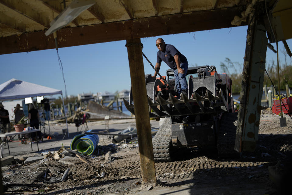 Un contratista endereza un poste en Getaway Marina, un negocio perteneciente a Robert Leisure, el cual ha iniciado el proceso de reconstruirlo tras el paso del huracán Ian, el 2 de octubre de 2022, en el Boulevard San Carlos de Fort Myers Beach, Florida. (AP Foto/Rebecca Blackwell)