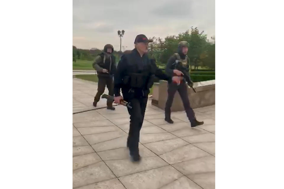 FILE - In this Aug. 23, 2020, file frame from video provided by the State TV and Radio Company of Belarus, President Alexander Lukashenko, foreground, walk near the Palace of Independence in Minsk, Belarus. Lukashenko’s office released a video showing him landing in a helicopter nearby and brandishing a Kalashnikov rifle as thousands of anti-government protesters marched nearby. He called the demonstrators “rats” as he inspected riot police guarding the residence. (State TV and Radio Company of Belarus via AP, File)