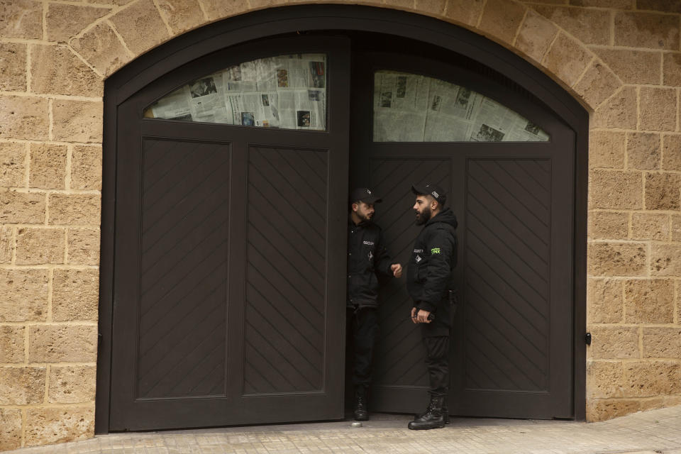 Private security guards confer at the garage door of the house of ex-Nissan chief Carlos Ghosn in Beirut, Lebanon, Tuesday, Jan. 7, 2020. Tokyo prosecutors obtained an arrest warrant Tuesday for the wife of Nissan's former chairman, Ghosn, on suspicion of perjury, adding to the couple's legal troubles in the country where he once was revered as a star executive. (AP Photo/Maya Alleruzzo)