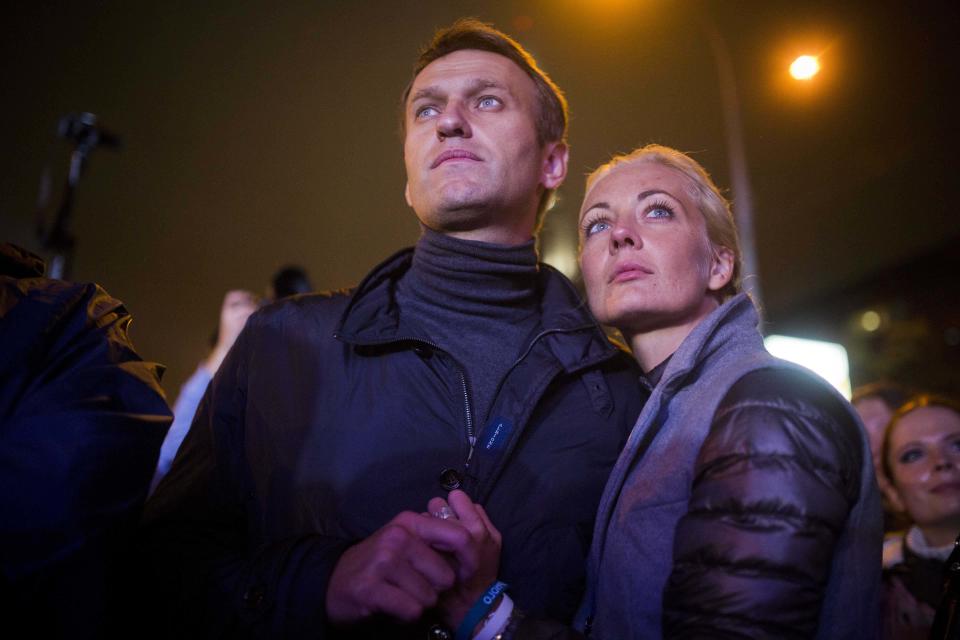 FILE - Russian opposition leader Alexei Navalny, left, and his wife Yulia after a rally in rain-soaked Moscow, Russia, Friday, Sept. 6, 2013. The opposition leader rose to prominence with his investigations into corruption which turned otherwise dull financial stories into internet blockbuster viewing. (AP Photo/Evgeny Feldman, File)