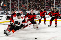 Philadelphia Flyers defenseman Sean Walker (26) skates with puck in the second period of an NHL Stadium Series hockey game against the New Jersey Devils in East Rutherford, N.J., Saturday, Feb. 17, 2024. (AP Photo/Peter K. Afriyie)