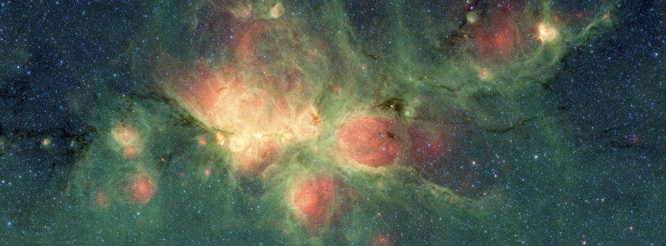 This image made available by NASA shows the Cat's Paw Nebula inside the Milky Way Galaxy located in the constellation Scorpius, captured by NASA's Spitzer Space Telescope. Its distance from Earth is estimated to be between 1.3 kiloparsecs (about 4,200 light years) to 1.7 kiloparsecs (about 5,500 light years). The bright, cloudlike band running left to right across the image shows the presence of gas and dust that can collapse to form new stars. The black filaments running through the nebula are particularly dense regions of gas and dust. The entire star-forming region is thought to be between 24 and 27 parsecs (80-90 light years) across. (NASA/JPL-Caltech via AP)