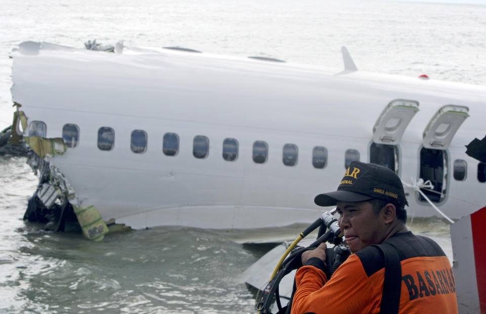 A rescue worker prepare to retrieve a Lion Air jet plane’s cockpit voice recorder out of the wreckage of the plane near the Ngurah Rai International airport in Kuta, Bali, Indonesia on Monday, April 15, 2013. The Indonesian passenger jet carrying 108 people missed the runway as it came into land on the resort island on Saturday, slamming into the water at high speed and splitting in two. (AP Photo/Firdia Lisnawati)