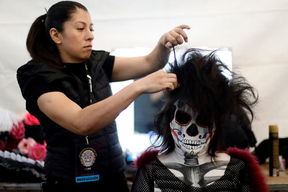 A woman gets make-up before taking part in a procession to commemorate Day of the Dead in Mexico City on Saturday.