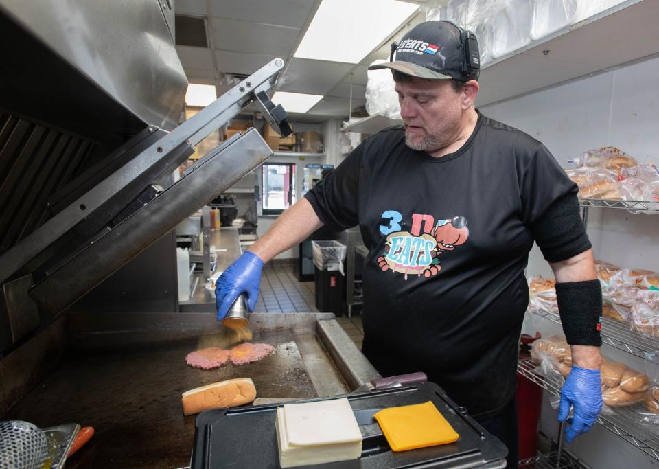 Owner Sean DeSmet grills a double cheeseburger at 3-D Eats’ newest location at the former Checkers Drive-In at the corner of North Pace Boulevard and West Fairfield Drive in Pensacola on Monday, Oct. 9, 2023.