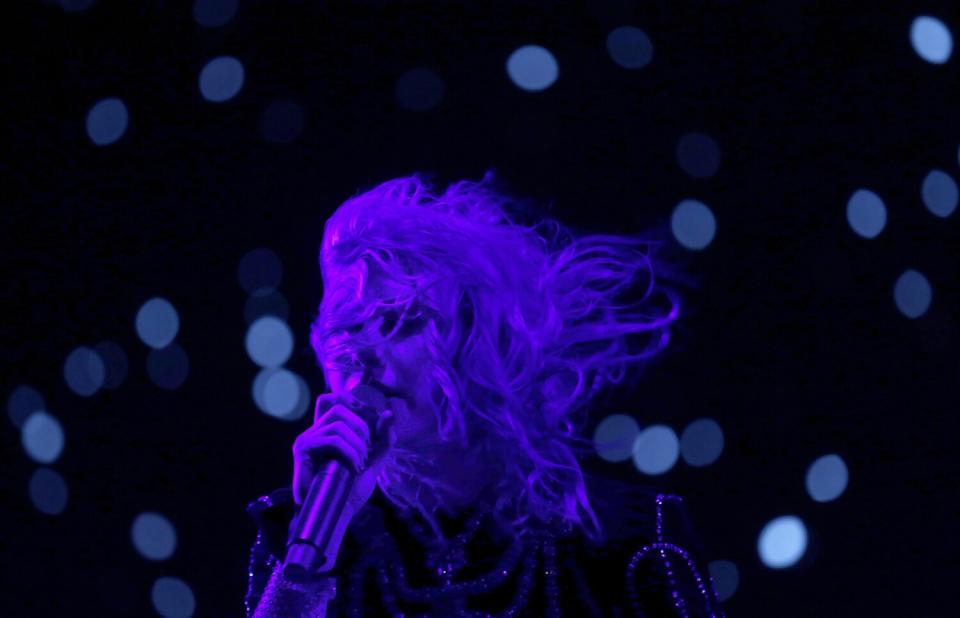 Phoebe Bridgers performs in the darkness.