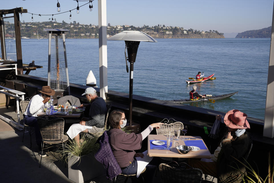 People dine outdoors at The Trident restaurant Friday, Dec. 4, 2020, in Sausalito, Calif. The health officers in six San Francisco Bay Area regions have issued a new stay-at-home order as the number of virus cases surge and hospitals fill. The changes announced Friday will take effect in most of the area at 10 p.m. Sunday and last through Jan. 4. It means restaurants will have to close to indoor and outdoor dining, bars and wineries must close along with hair and nail salons and playgrounds. (AP Photo/Eric Risberg)