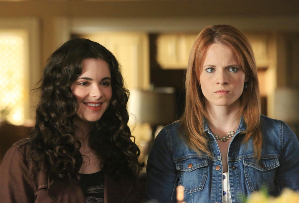 Vanessa Marano and Katie Leclerc smile and pose indoors. Vanessa has curly hair and wears a casual top. Katie has straight hair, wears a denim jacket and a necklace