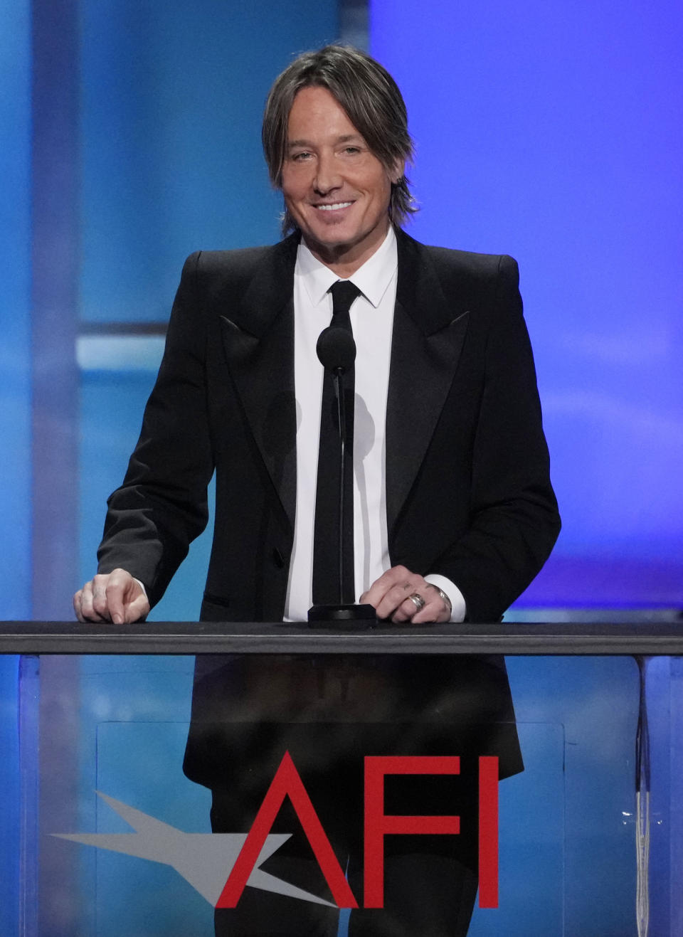 Keith Urban speaks from the stage during the 49th AFI Life Achievement Award tribute to his wife Nicole Kidman, Saturday, April 27, 2024, at the Dolby Theatre in Los Angeles. (AP Photo/Chris Pizzello)