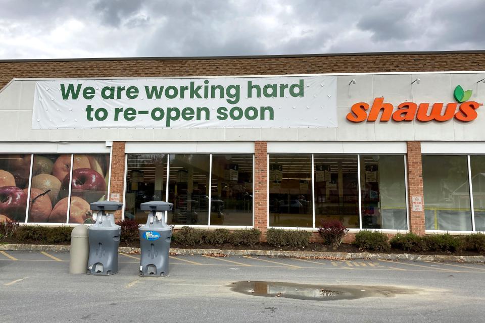 A sign is attached to the exterior of a closed grocery store, Thursday, Oct. 19, 2023, in Ludlow, Vermont, three months after severe flooding hit the ski town. The store, which has not said when it will reopen, is doing online orders.