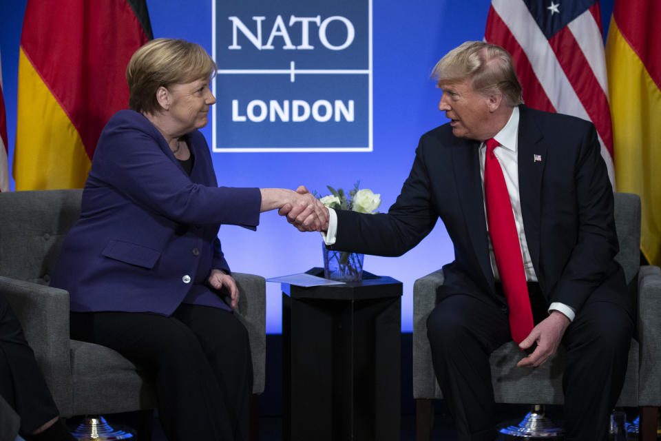 In this Wednesday, Dec. 4, 2019 file photo, President Donald Trump shakes hands with German Chancellor Angela Merkel during the NATO summit at The Grove in Watford, England. Trump has publicly berated European allies and Canada in the past for not spending enough on defense budgets. (AP Photo/ Evan Vucci, File)