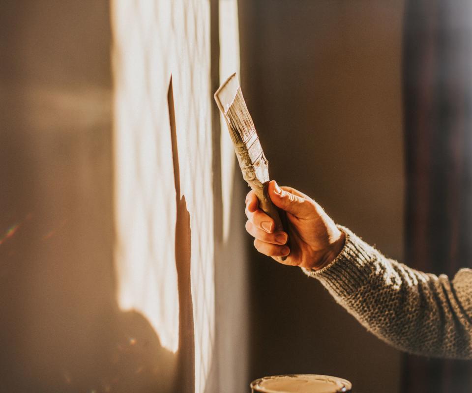 Someone painting a wall with a brush