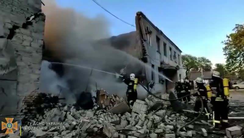 Firefighters spray water onto fire in a destroyed building after a missile strike, in Odesa