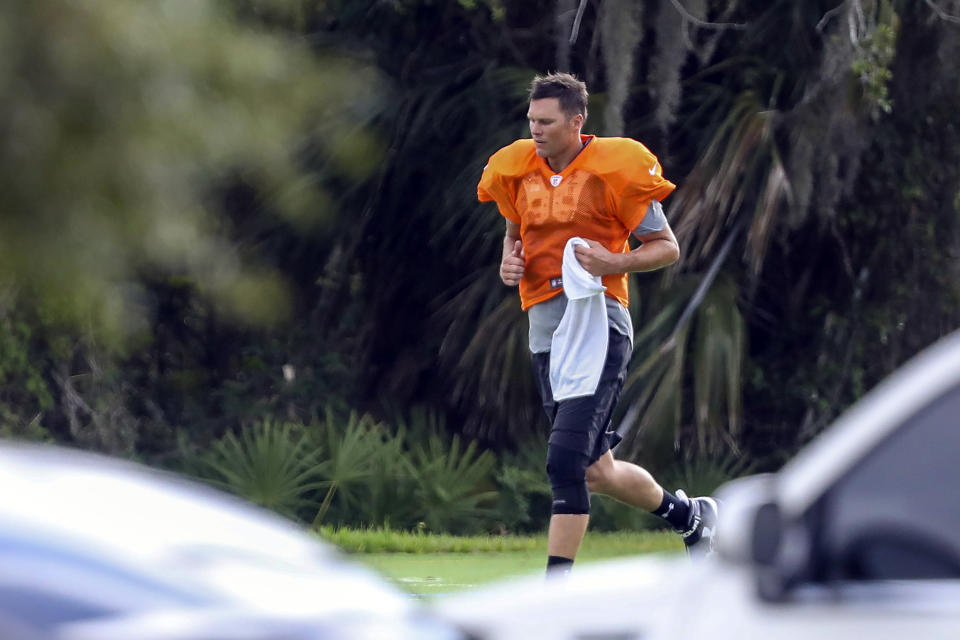 FILE - In this May 19, 2020, file photo, Tampa Bay Buccaneers quarterback Tom Brady runs across the field during a an NFL football workout at Berkeley Preparatory School in Tampa, Fla. Bruce Arians didn’t give much thought to the prospect of opting out of trying to help Tom Brady win a Super Bowl with the Tampa Bay Buccaneers. The 67-year-old whose aggressive offensive philosophy is dubbed “no risk it, no biscuit” is one of the oldest head coaches in the NFL, as well as a cancer survivor who once retired because of health concerns. (Chris Urso/Tampa Bay Times via AP, File)