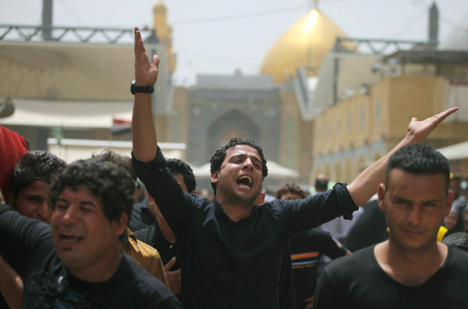 Friends of Mustafa Mounir, 19, chant slogans against the al-Qaida breakaway group Islamic State of Iraq and the Levant (ISIL), while carrying his flag-draped coffin during his funeral procession in Najaf, 100 miles (160 kilometers) south of Baghdad, Iraq, Friday, April 18, 2014. Mustafa Mounir was killed in a car bomb attack in Baghdad on Thursday, his family said. (AP Photo/Jaber al-Helo)